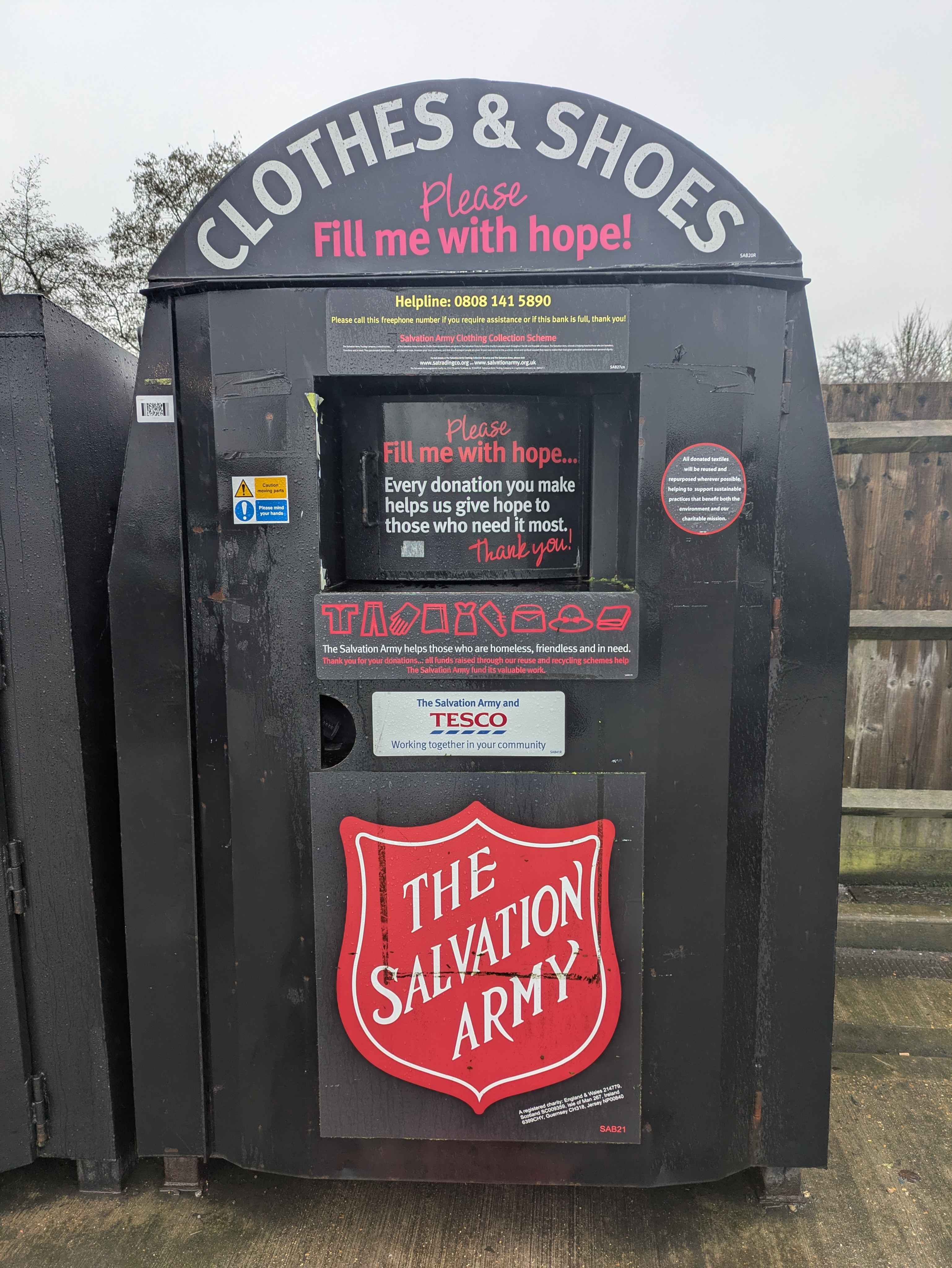A black Salvation Army clothes and shoes donation bank, with the slogan 'Please fill me with hope'