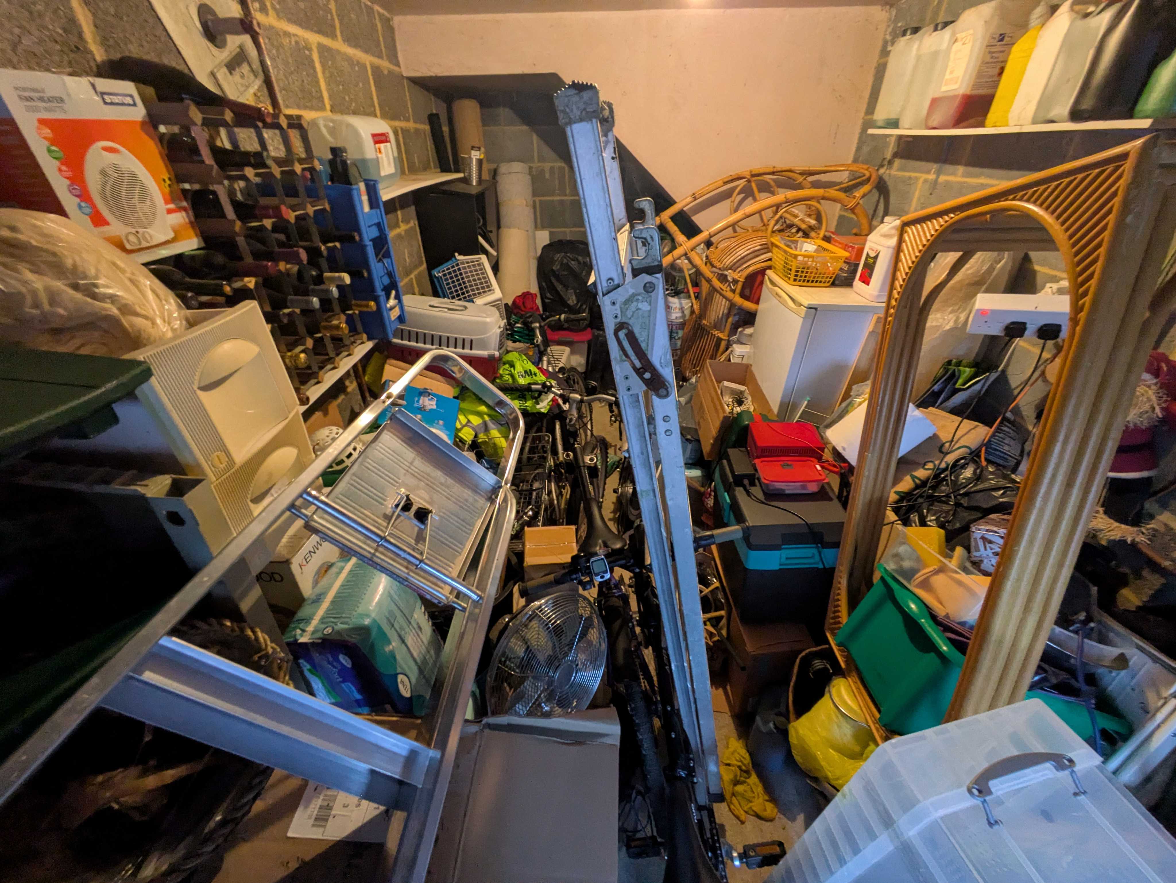 A garage packed wall-to-wall with tools, boxes, bikes and bric-a-brac before clearance